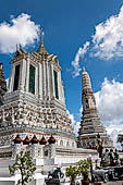 Bangkok Wat Arun - The porch facing ithe cardinal direction with statue of the Buddha in front and one satellite prang on the background.